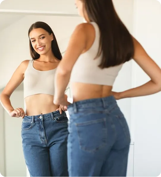 Woman comparing her old and new jeans after weight loss